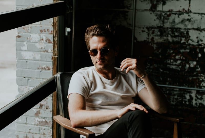 Ein Mann mit Brille sitzt auf einem Sessel