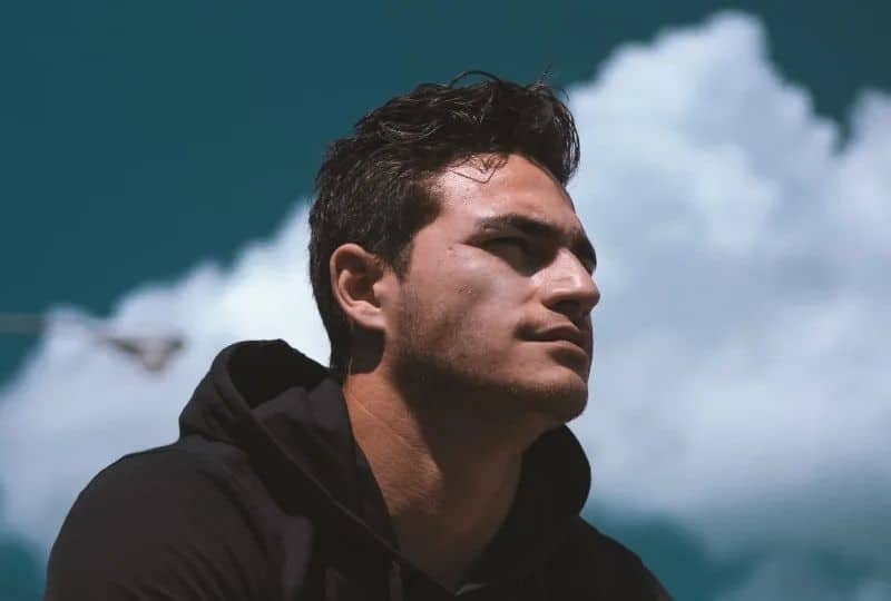 Ein Mann in einem schwarzen Sweatshirt schaut in die Ferne