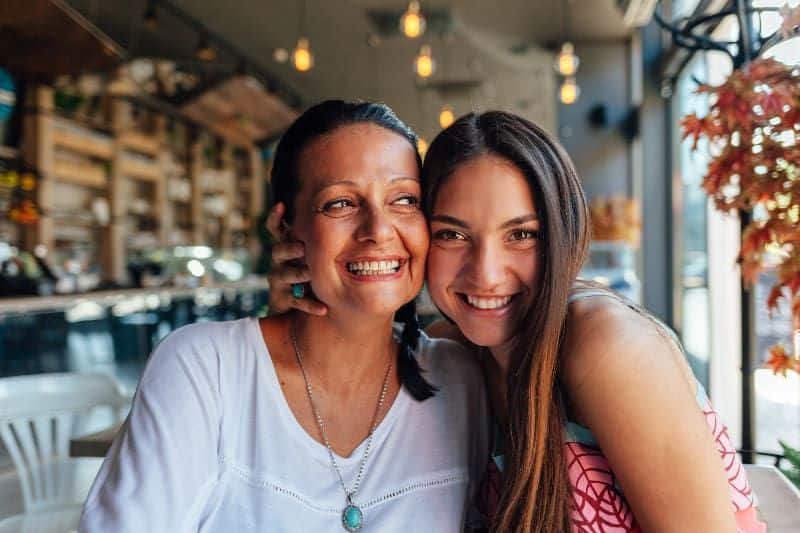 lächelnde Mutter und Tochter im Cafe