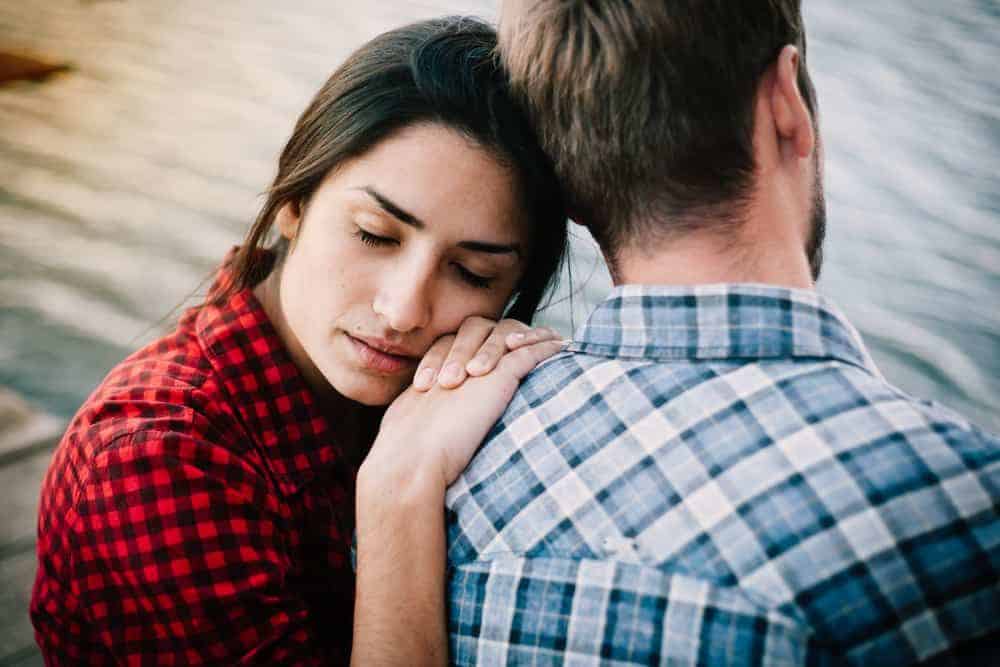 Eine traurige Frau stützte sich auf die Schulter ihres Mannes