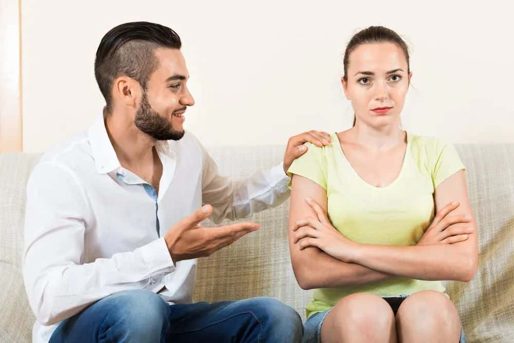 Ein Mann mit Bart verspottet eine traurige Frau