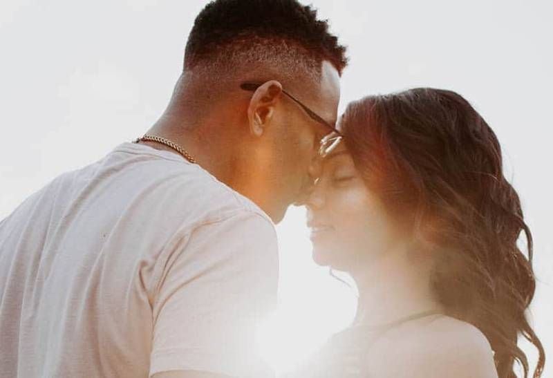 Mann küsst Frau Nase während des Sonnenuntergangs