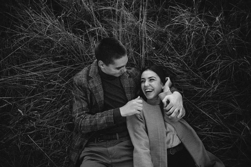 ein junges Liebespaar, das im Heu umarmt liegt