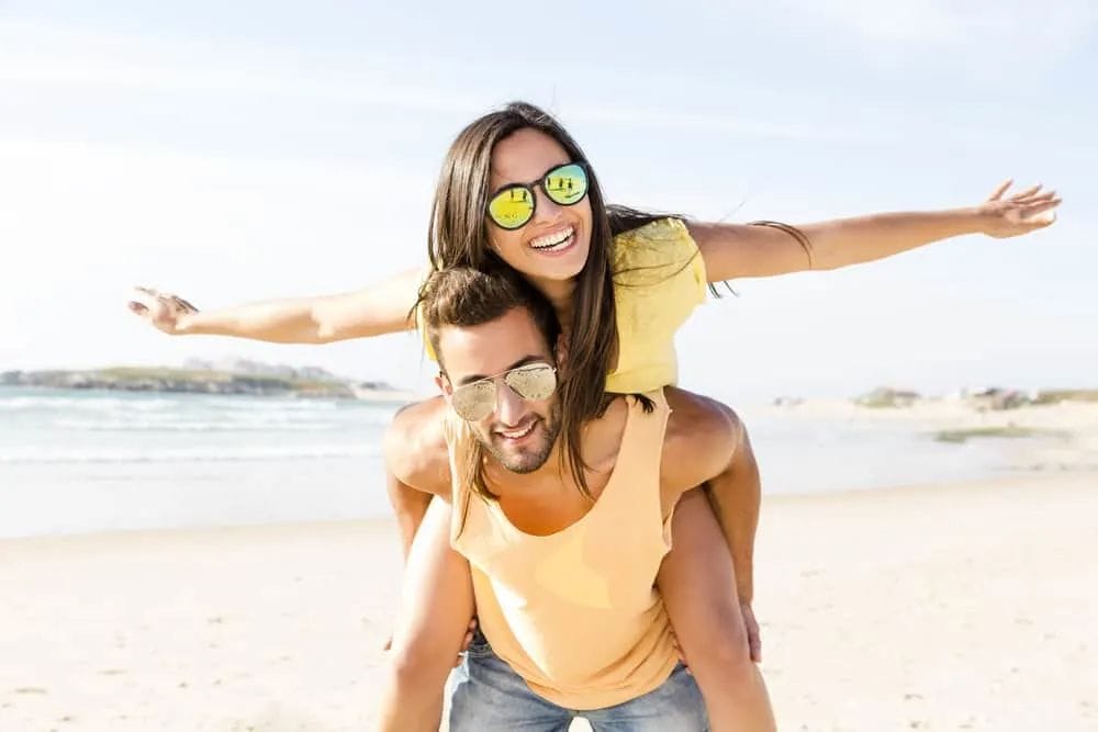 Ein Mann trägt eine Frau und lacht