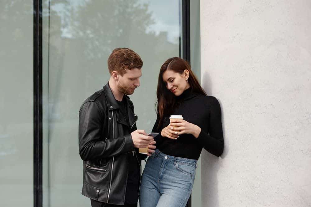 Ein Mann in einer schwarzen Jacke spricht mit einem lächelnden Mädchen