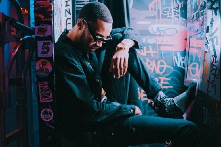 Mann sitzt auf dem Boden im Freien