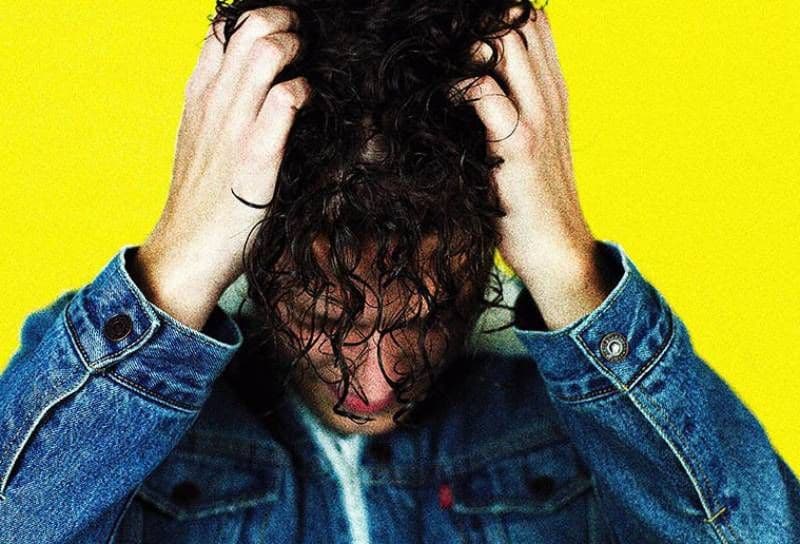 Mann hält seinen Kopf