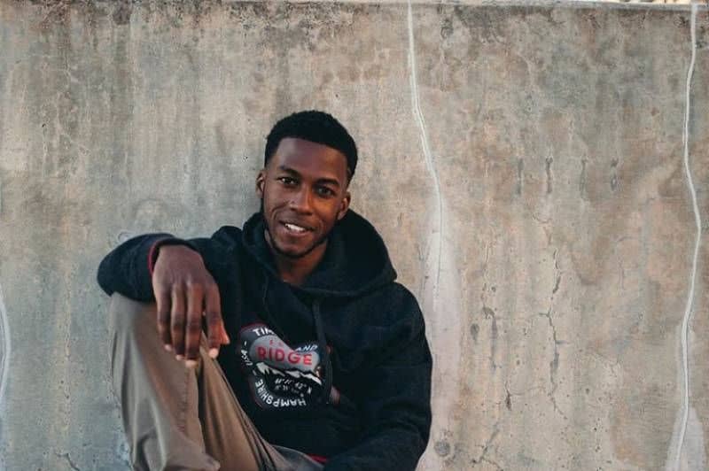 schwarzer Mann sitzt auf der Straße