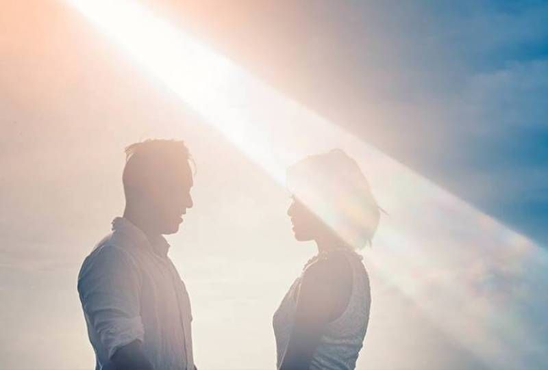 ein Paar, das bei Sonnenaufgang die Hände hält