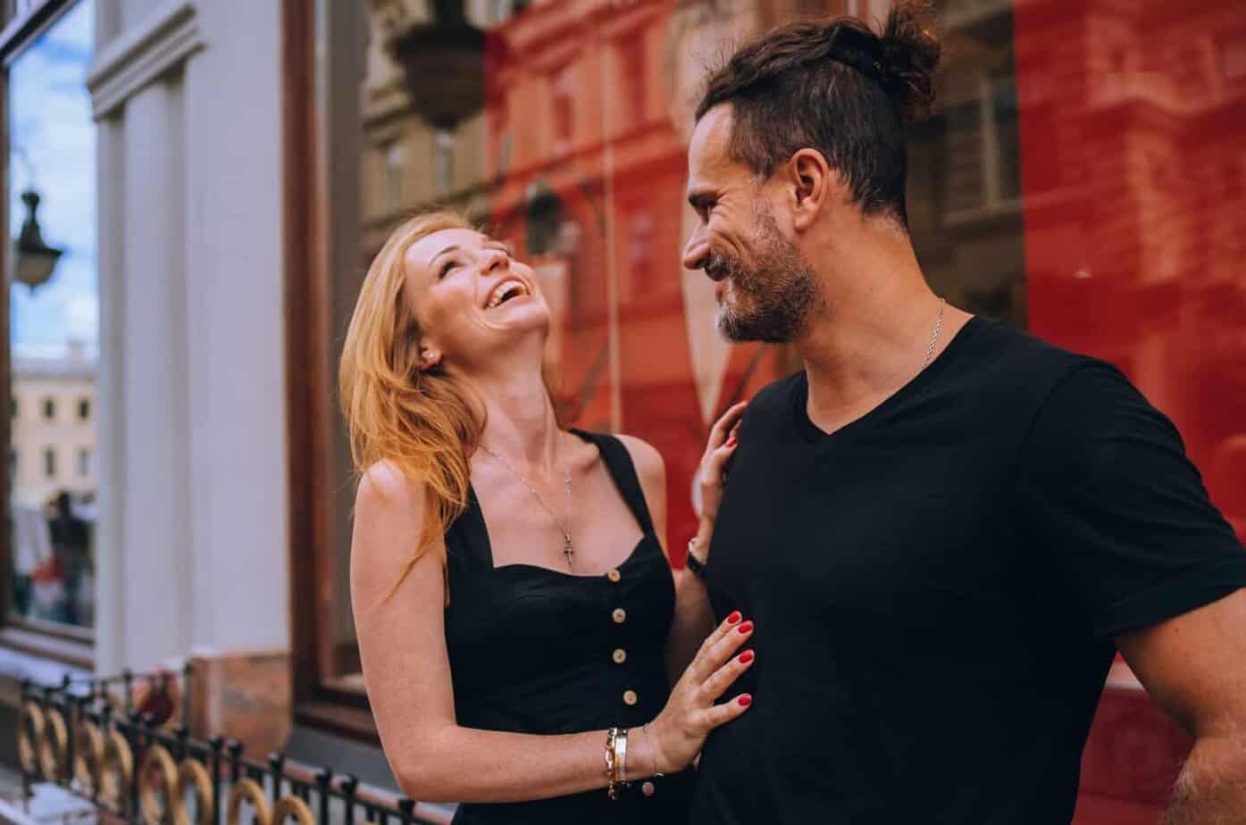 Frau lacht und berührt ihren Freund im Freien