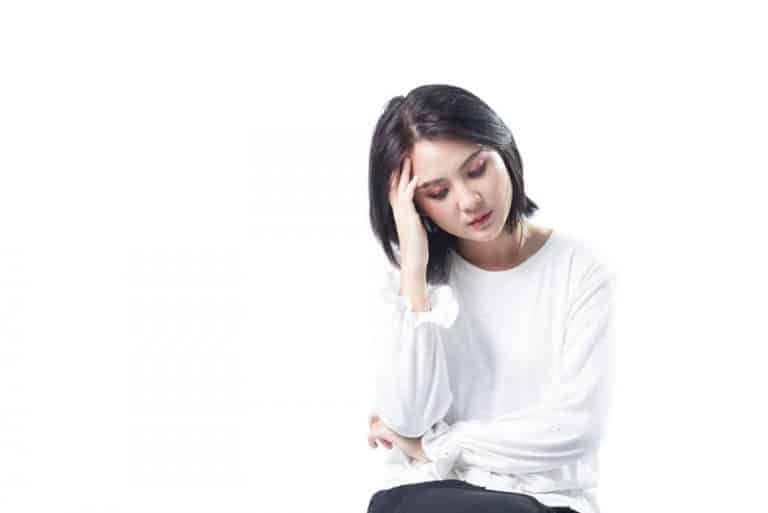 ein Mädchen sitzt und bewacht ihren Kopf