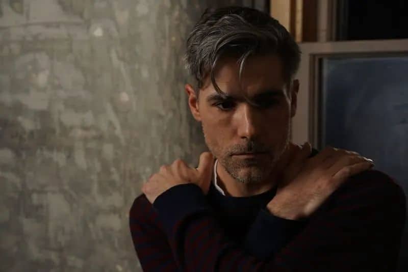 Ein einsamer Mann sitzt in einem dunklen Raum