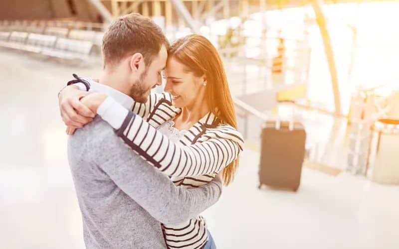 ein paar umarmen sich beim treffen nach einer reise