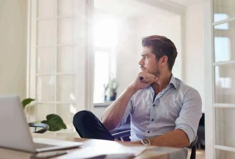 Mann sitzt am Tisch und schaut weg