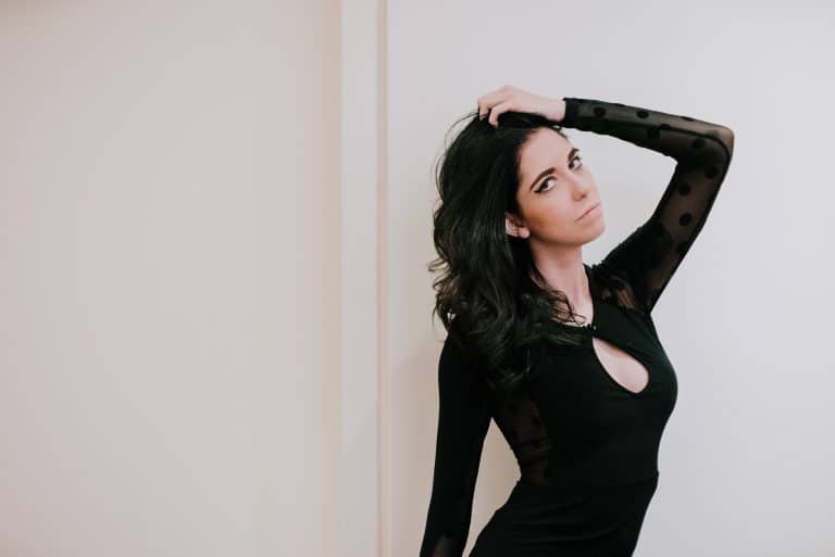 Das Mädchen im schwarzen Body posiert