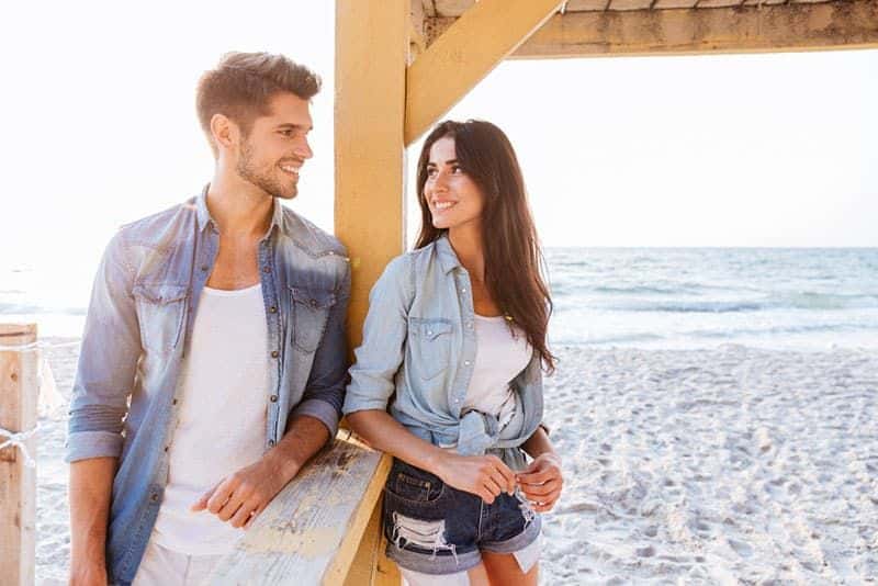 glückliches Paar, das auf dem Sand steht