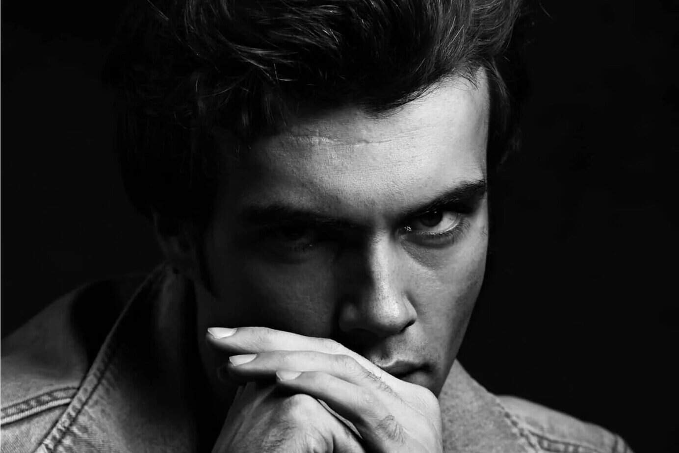 ein Porträt eines ernsthaften gutaussehenden Mannes im Dunkeln