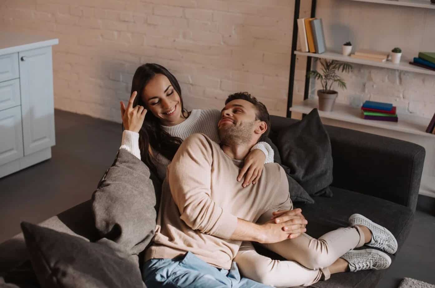 frau umarmt mann auf sofa