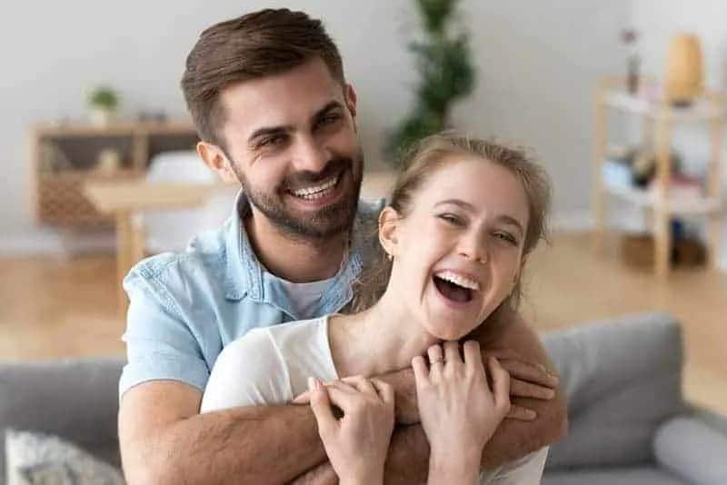 Mann umarmt Frau von hinten