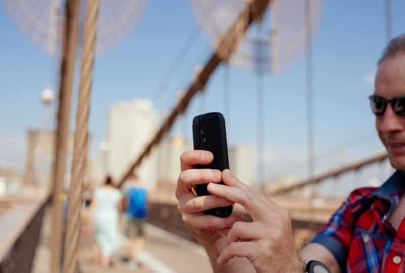 Mann auf der Brücke macht ein Selfie