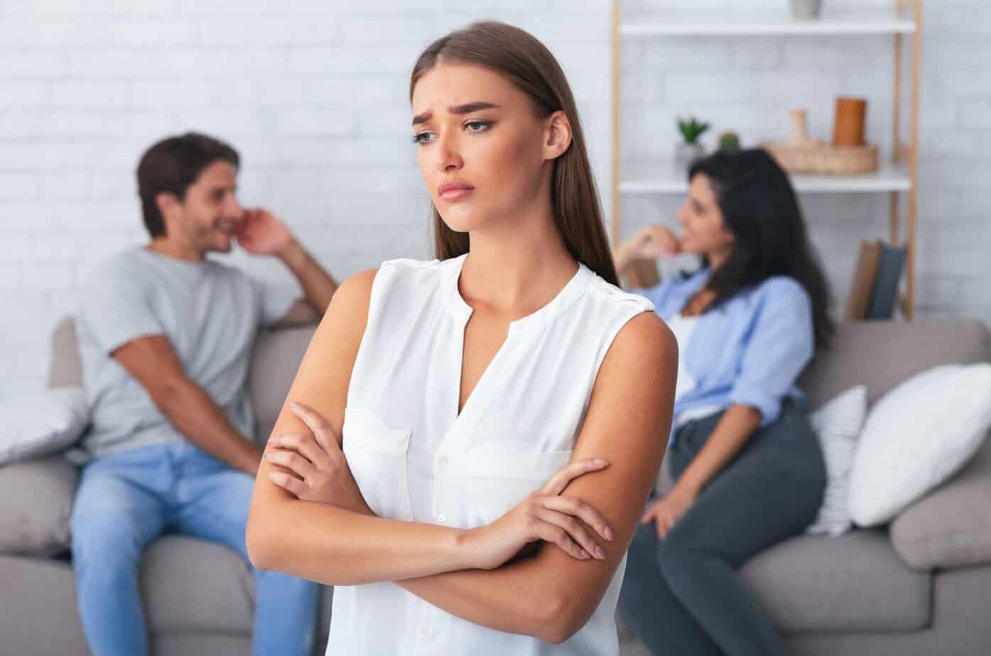 traurige Frau mit Paerchen im Hintergrund