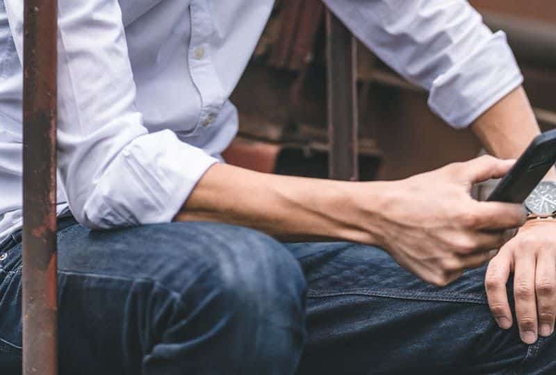 Mann im weißen Hemd, das blaue Sonnenbrille trägt