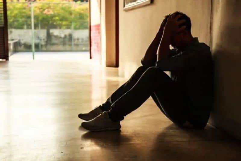 ein besorgter Mann sitzt auf dem Boden