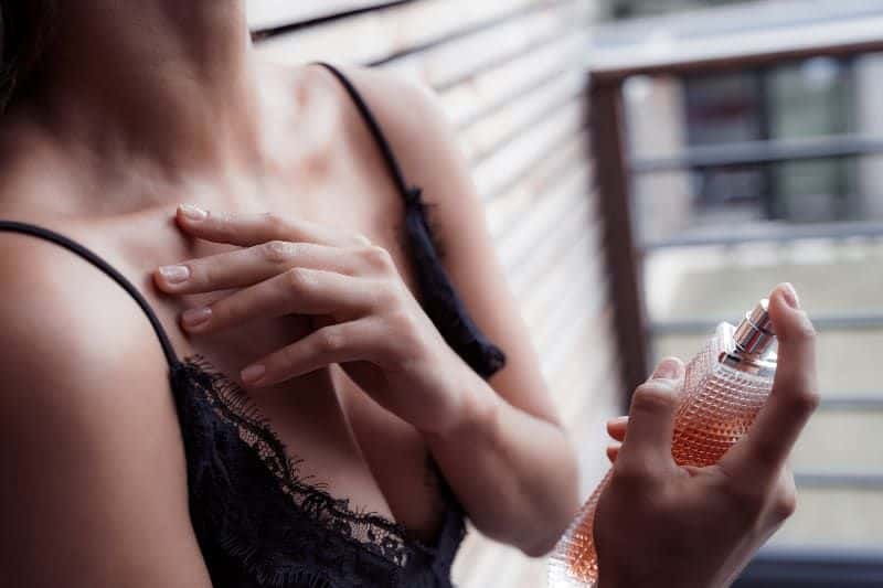 eine junge Dame, die Parfüm anzieht