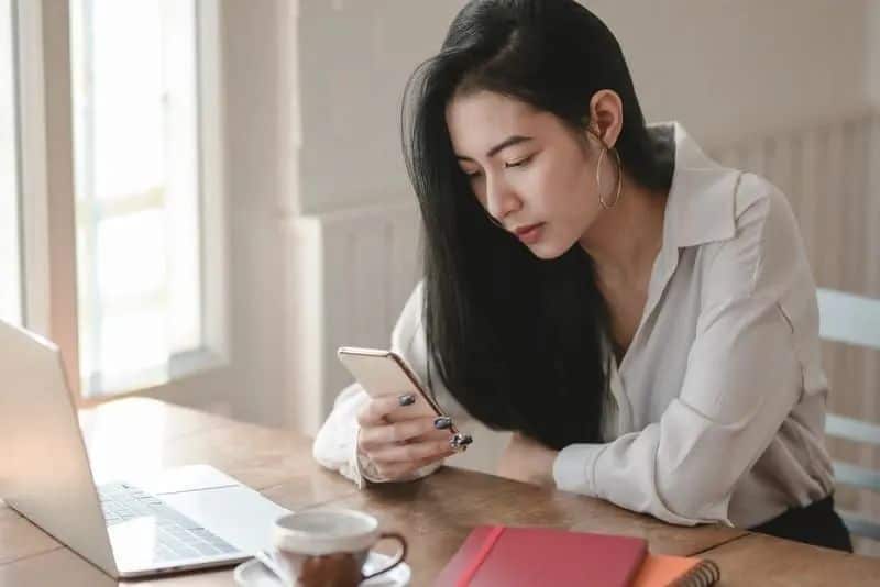 besorgte Frau sitzt und SMS