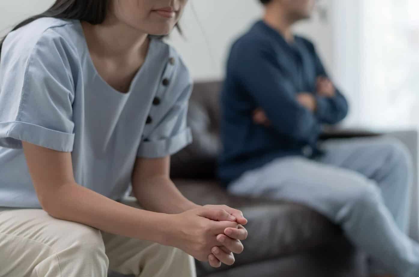 Mann und Frau sitzen verärgert auf der Couch