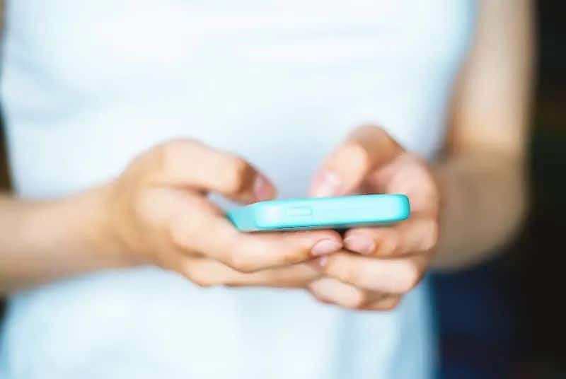 Das Mädchen hält ein Handy in den Händen (2)