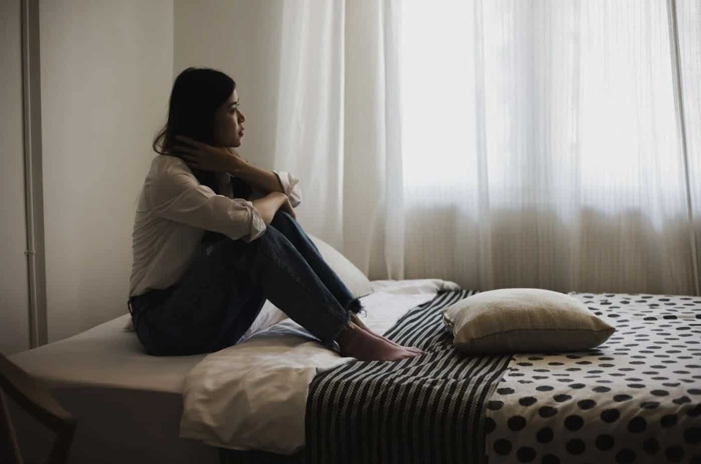 Frau sitzt auf dem Bett