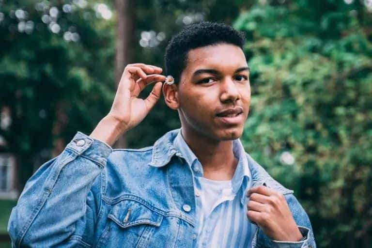 ein Mann, der eine Blume hinter sein Ohr legt