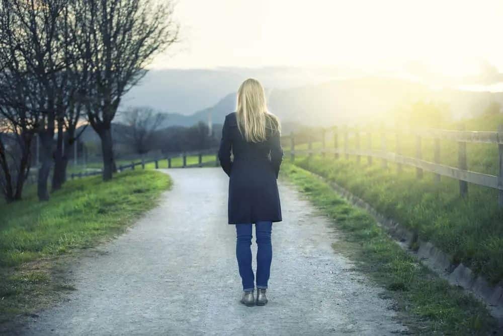 Die Blondine im Mantel steht alleine im Weg