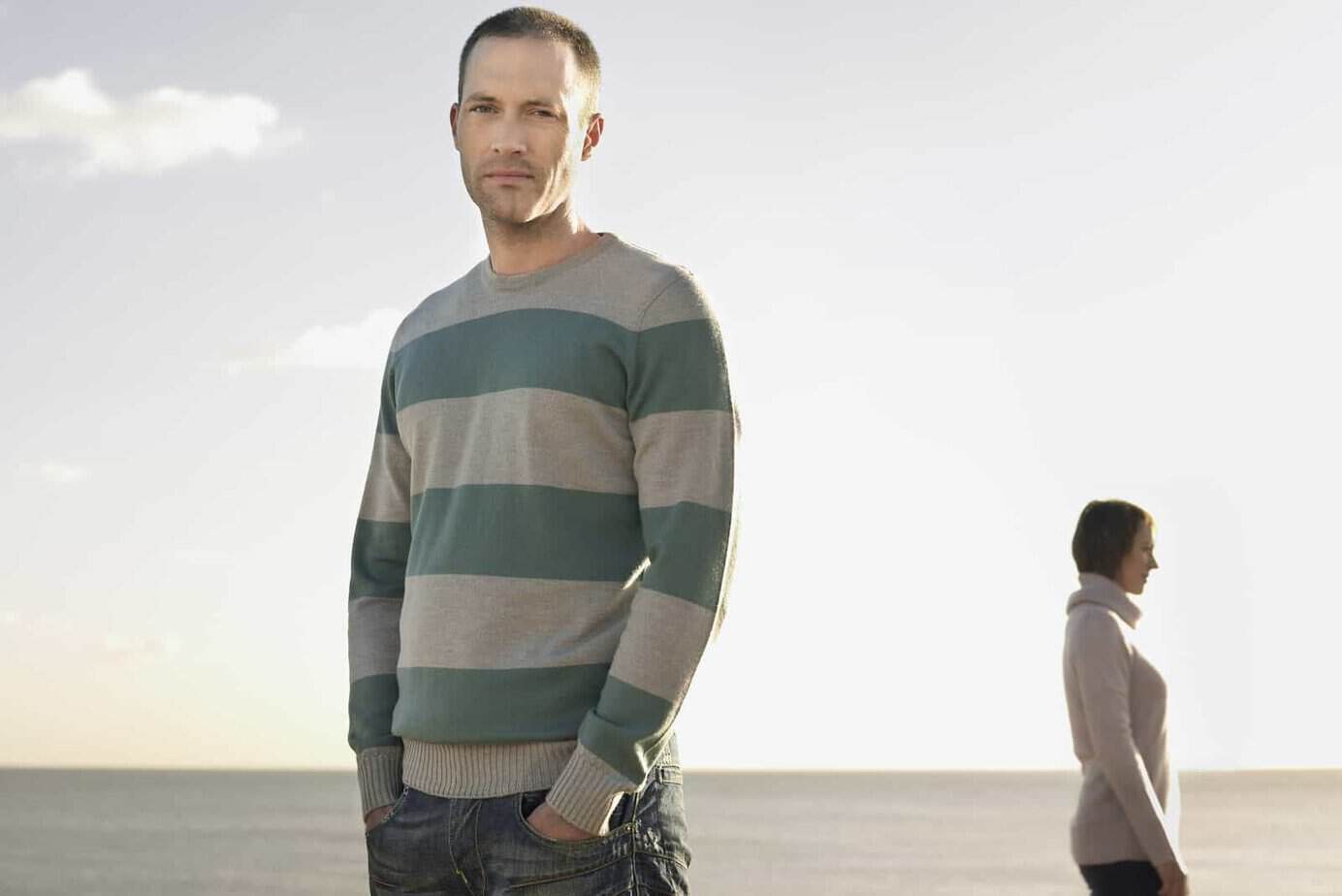 Porträt eines Mannes mit Frau im Hintergrund am Strand