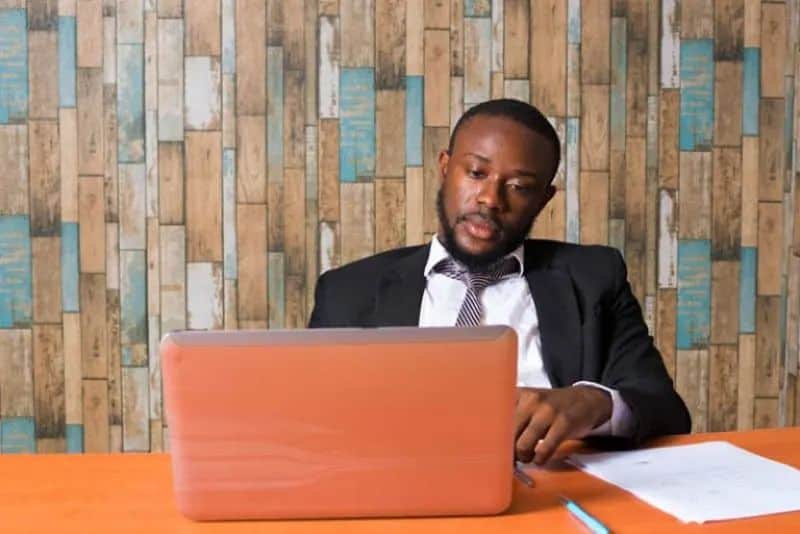 ein schwarzer Mann, der an einem Laptop arbeitet