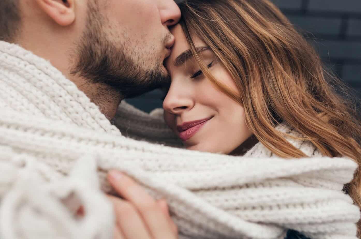 mann kuesst frau auf stirn