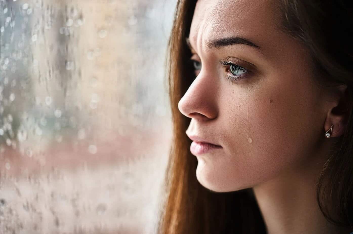 frau am fenster weint