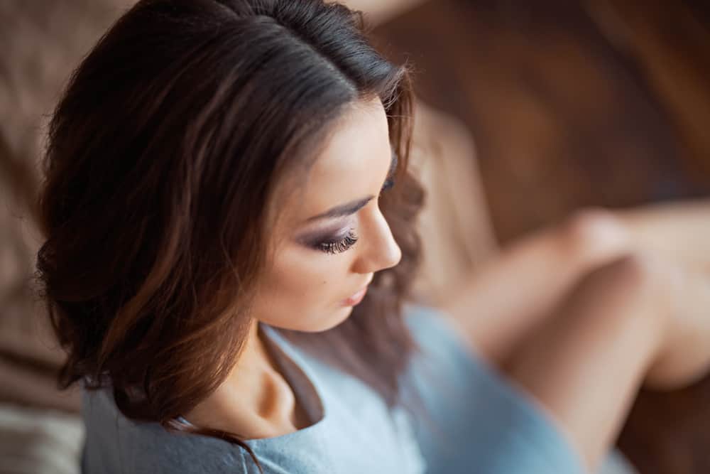 Ein Mädchen in einem grauen engen Kleid sitzt