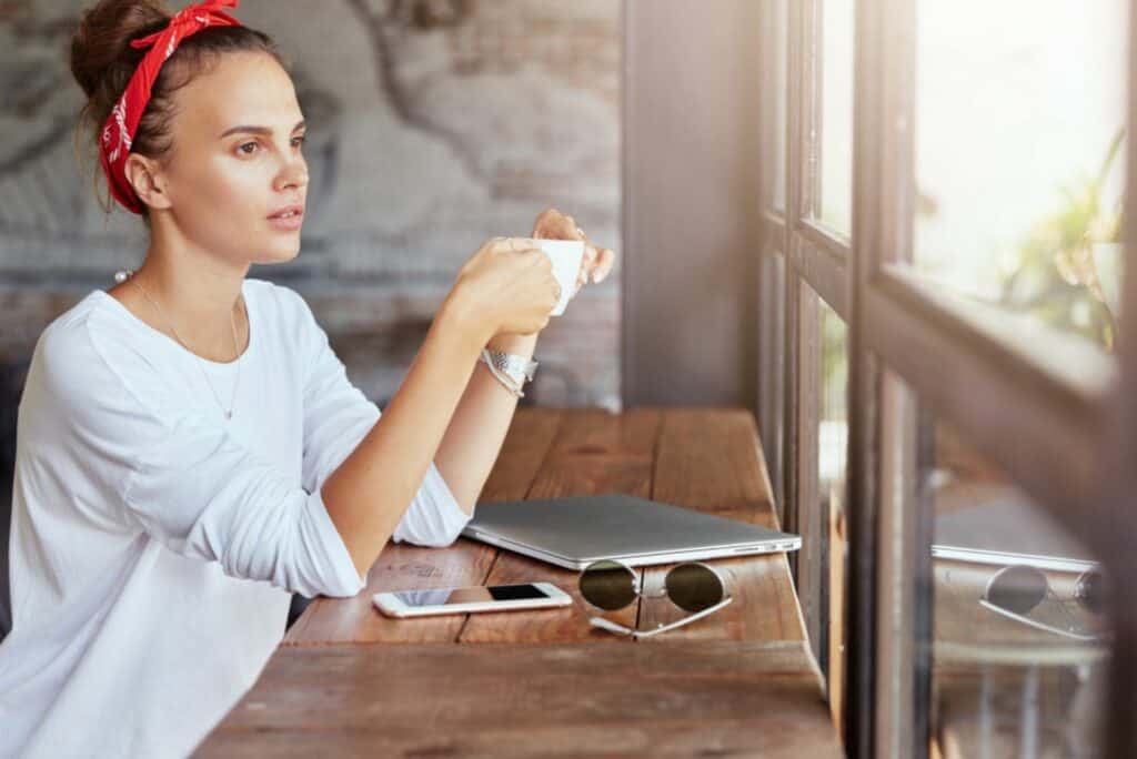 Ein nachdenkliches Mädchen sitzt an einem Tisch in einem Café