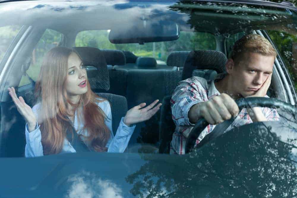 Ein wütender Mann im Auto hört seiner Frau zu