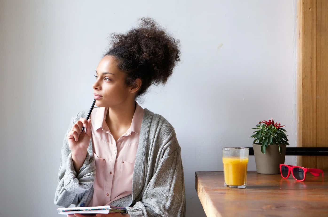 Frau am Schreibtisch denkt nach