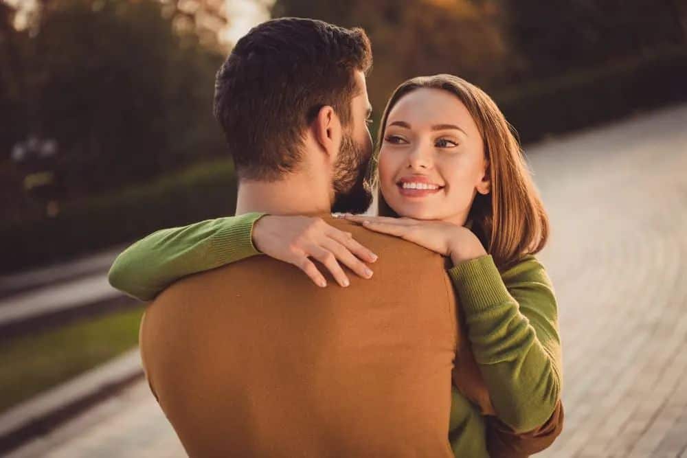 draußen steht in den Armen einer schönen Frau und eines Mannes mit Bart