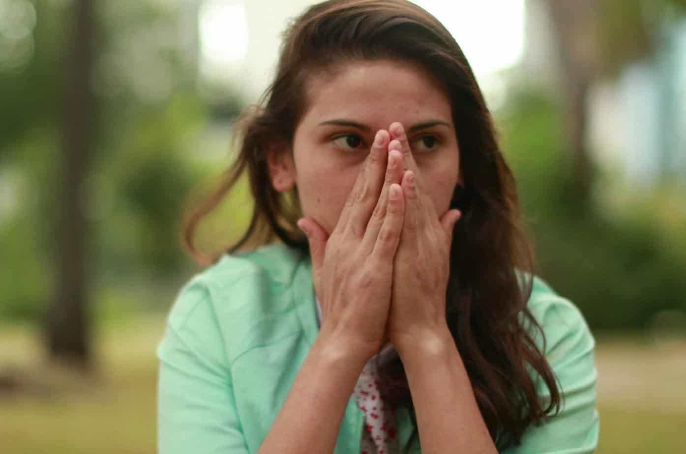junge Frau mit Händen im Gesicht