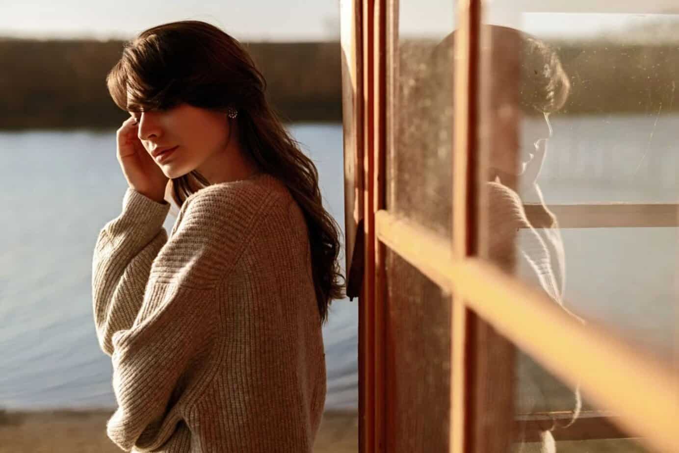 nachdenkliche Frau steht am Fenster im Freien