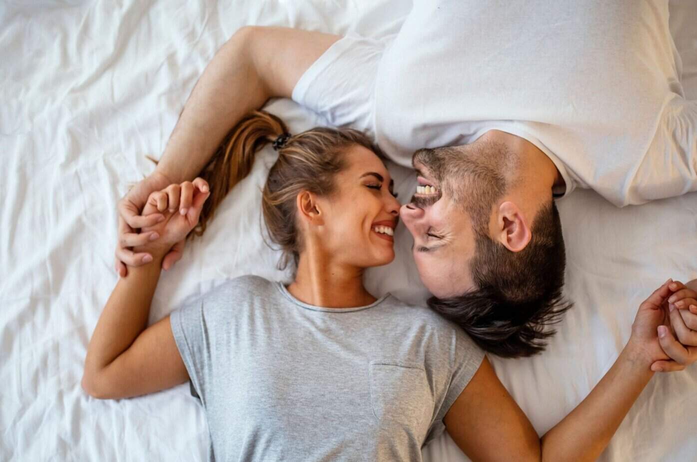 Parallell dating: Hvordan møte flere menn uten å få dårlig samvittighet Mann und Frau lachen im Bett