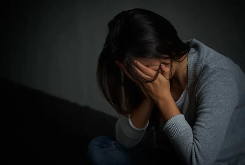 Eine Frau, die sich auf die Knie stützte und weinte