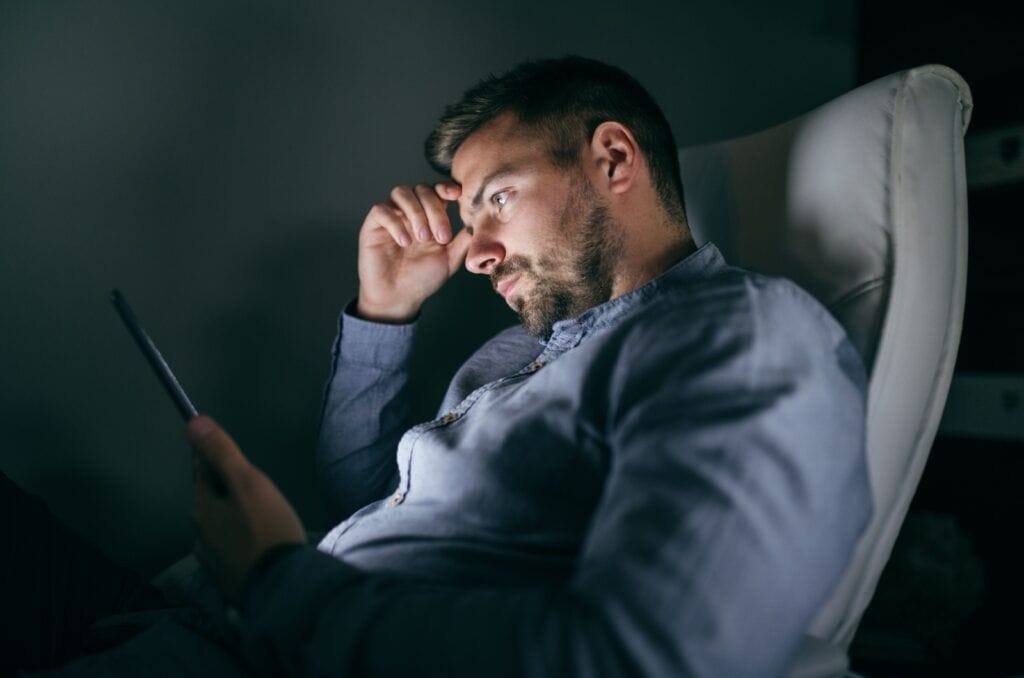 mann sitzt in der dunkelheit