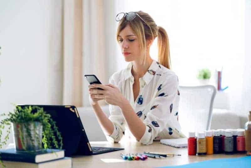 ein Mädchen sitzt im Büro und einen Schlüssel auf ihrem Handy(1)