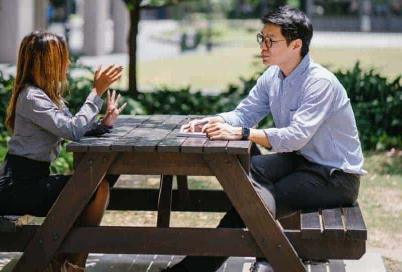 11 tegn på at han holder mulighetene åpne Mann und Frau sprechen draußen auf dem Tisch